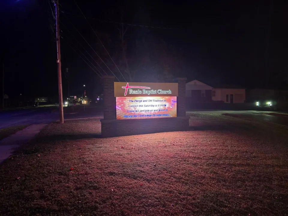 Outdoor LED display showing a church announcement after dark